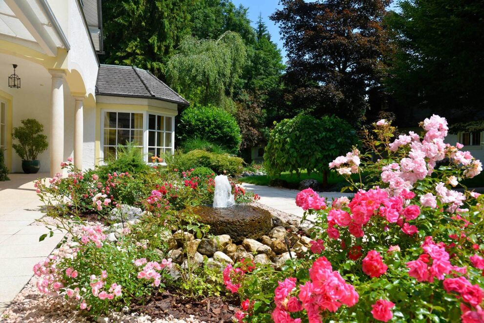 Blumenbeet mit Springbrunnen in der Garten- & Parkanlage des Hotels Seehhof Mondsee