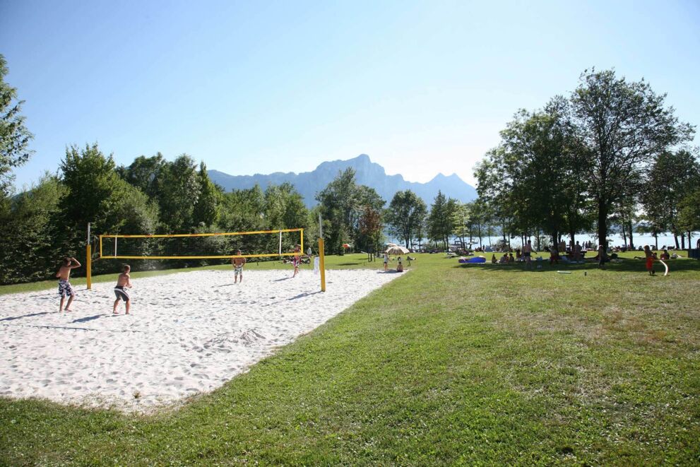 Beachvolleyballplatz mit Spieler:innen im Sommer am Mondsee