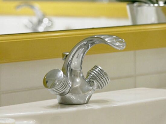 Ein Waschbecken mit Wasserhahn und einem Spiegel im Badezimmer des Hotels Seehof Mondsee