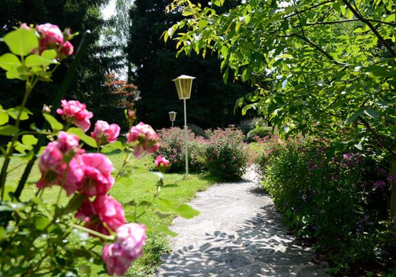 Gartenanlage mit Blumen zwischen Mondsee und Hotel Seehof