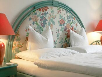 Doppelbett mit Nachttisch und -lampe im Hotel Seehof Mondsee im Salzkammergut