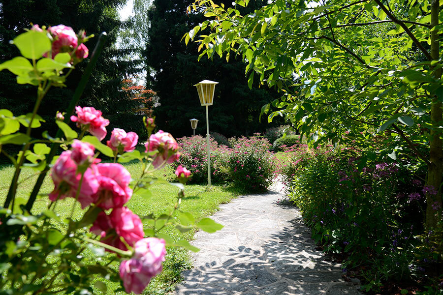 Gartenanlage mit Blumen zwischen Mondsee und Hotel Seehof Seehof Garten mit Rosen am Mondsee im Salzkammergut