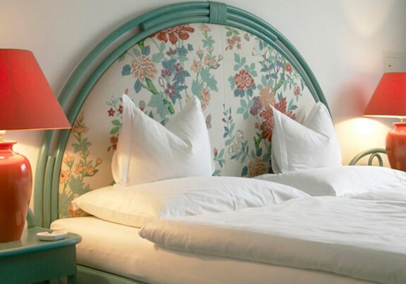 Doppelbett mit Nachttisch und -lampe im Hotel Seehof Mondsee im Salzkammergut