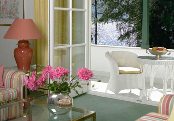 The suite at Hotel Seehof has a sofa, a coffee table and a balcony with lake view