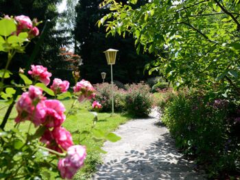 Gartenanlage mit Blumen zwischen Mondsee und Hotel Seehof