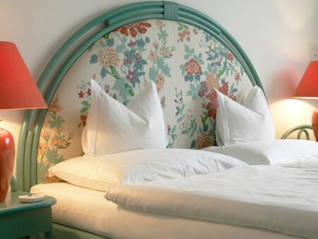 Doppelbett mit Nachttisch und -lampe im Hotel Seehof Mondsee im Salzkammergut