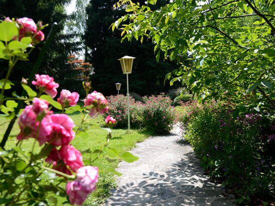 Gartenanlage mit Blumen zwischen Mondsee und Hotel Seehof