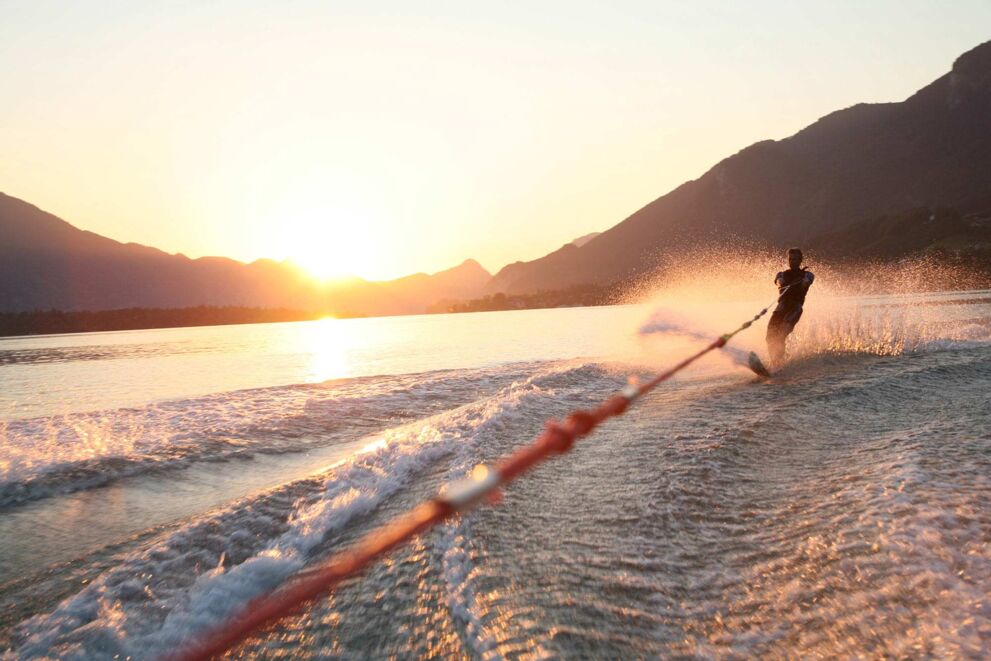 Im Sommerurlaub Sonnenuntergang bei Wasserskifahren auf dem Mondsee erleben