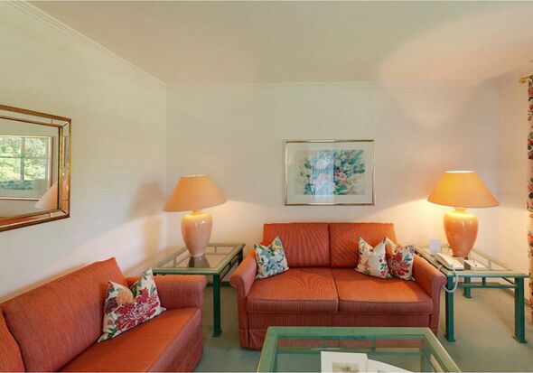 Eine orange-rote Sitzgarnitur steht in der Suite vom Hotel Seehof Mondsee