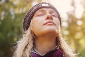 Frau atmet tief in der Natur ein